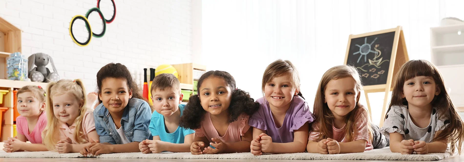 daycare kids laying on the floor looking at camera